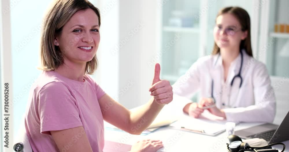 Portrait of smiling female patient showing thumbs up and recommending quality medical care in hospital. Quality medical care Portrait of smiling female patient showing thumbs up and recommending quality medical care in hospital. Quality medical care