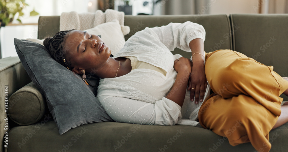 Home, pain and black woman on a couch, cramps and stomach with sickness, suffering and disease in the living room. African person, apartment and girl with abdominal problem, tummy ache and period - obrazy, fototapety, plakaty 