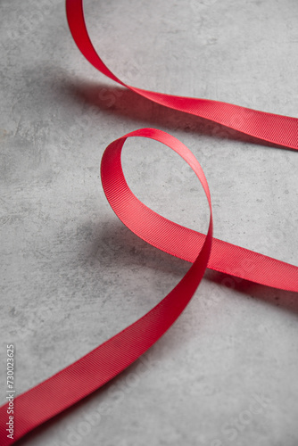 Satin ribbon fScarlet satin ribbon on a gray backgroundor a gift on a gray background photo