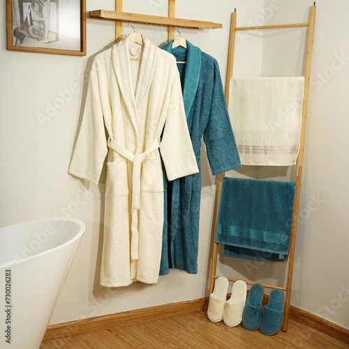 Bathrobe set - Hanger with clean bathrobe and towel on light wall bathrobe mockup