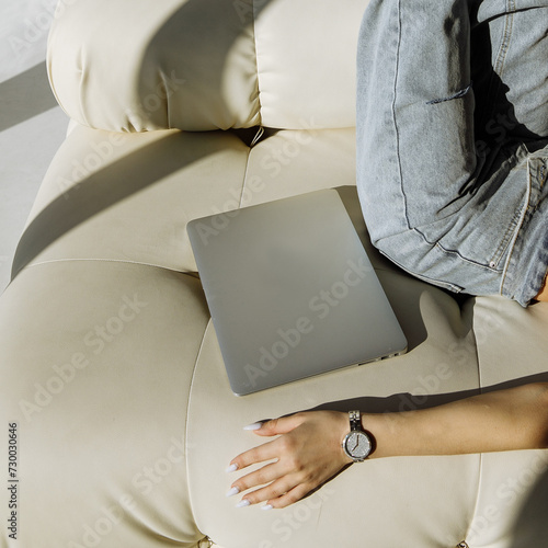 The girl is holding a laptop on a light background