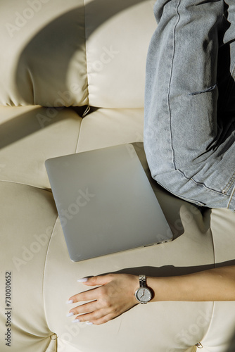 The girl is holding a laptop on a light background