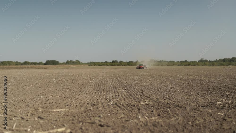 Green tractor seeding wheat on the field Green tractor seeding wheat on the field