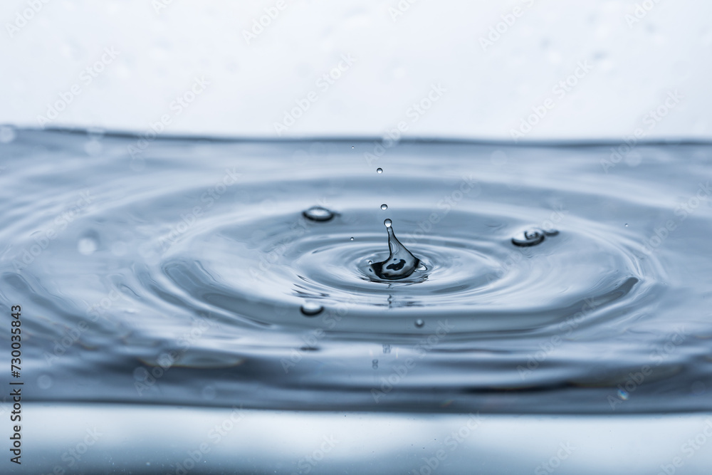 Reflecting water droplet and floating bubbles on a white background creating a small splash. Ideal for illustrating purity and tranquility. Reflecting water droplet and floating bubbles on a white background creating a small splash. Ideal for illustrating purity and tranquility.