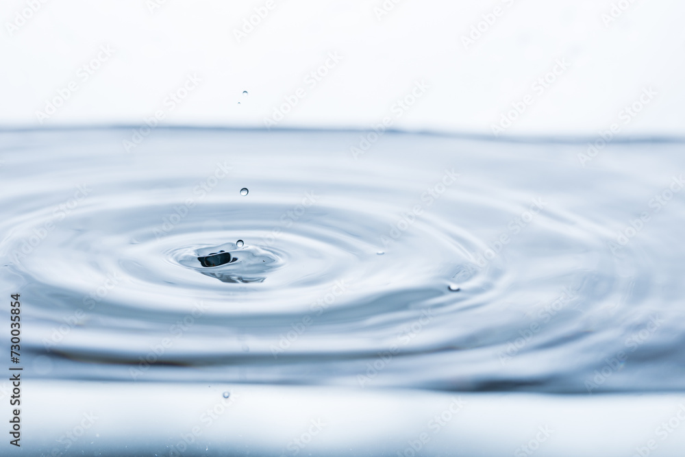 Captivating image of a water droplet creating ripples on a pristine white surface. Ideal for illustrating purity and tranquility Captivating image of a water droplet creating ripples on a pristine white surface. Ideal for illustrating purity and tranquility