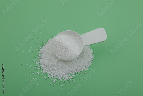 Pile of Sodium percarbonate powder SPC or sodium carbonate peroxide in measuring spoon. White granulated powder with formula Na2H3CO6 used in eco-friendly bleaches and other cleaning products