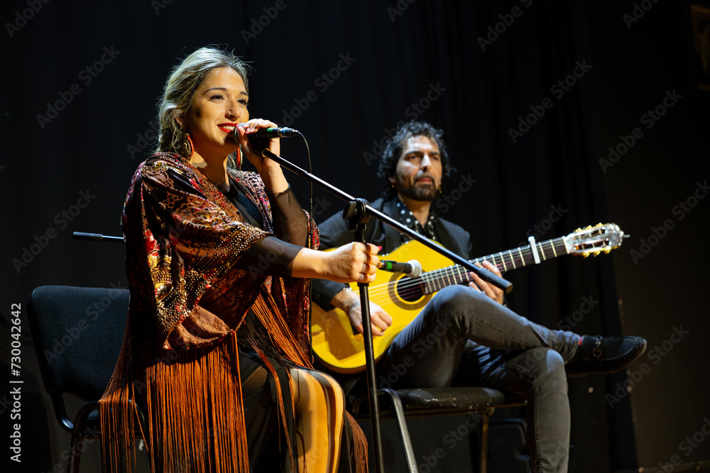 Obraz premium Flamenco performance with female singer and guitarist on stage, copy space.