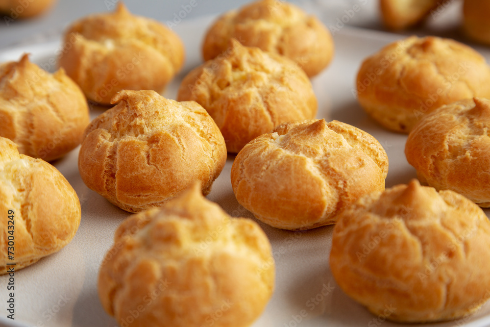 Homemade Mini Cream Puffs on a Plate, low angle view. Close-up. Homemade Mini Cream Puffs on a Plate, low angle view. Close-up.