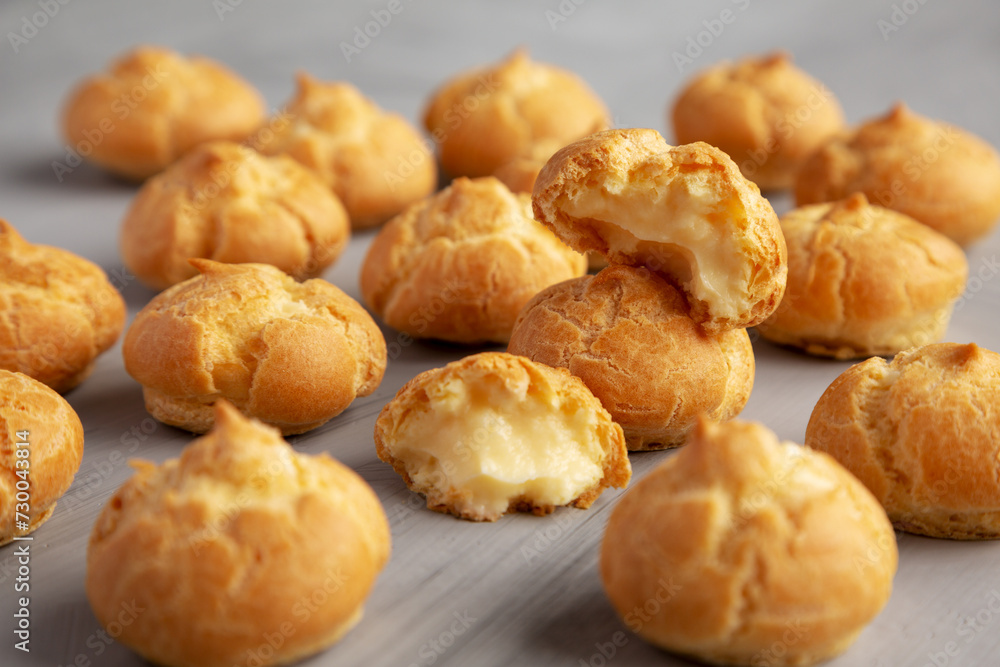 Homemade Mini Cream Puffs on a gray background, side view.