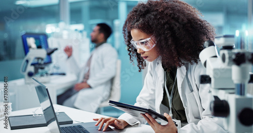 Laptop, woman or scientist in laboratory with tablet or research for chemistry report or medical test. Doctor, person typing or science update for online medicine development or virus news on website photo