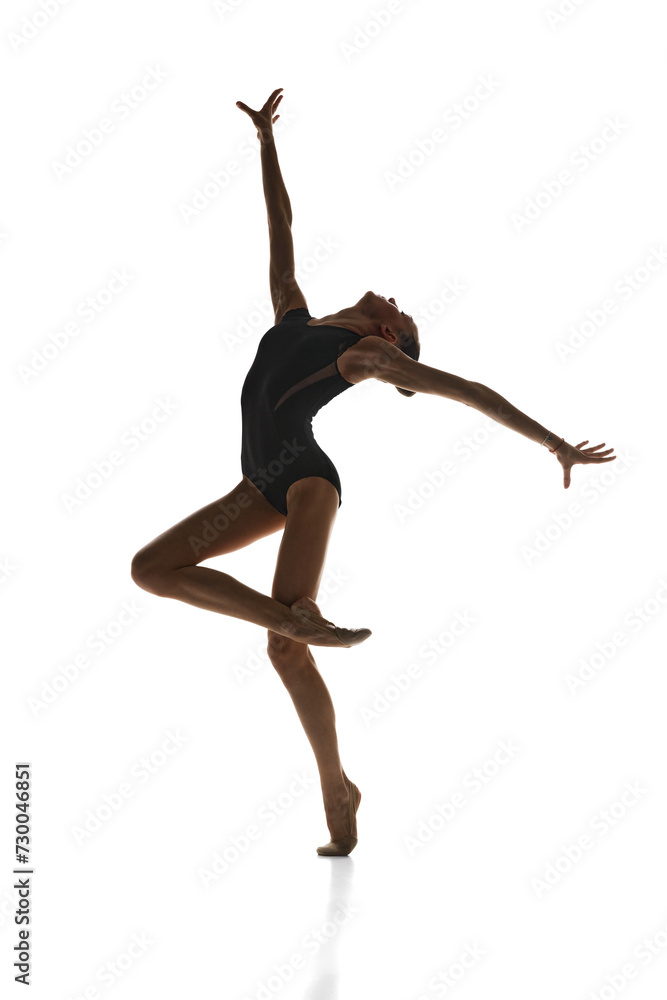 Obraz premium Full-length image of talented, artistic teen girl, rhythmic gymnast in stage costume performing against white studio background. Concept of sport, beauty and grace, competition, art, youth, hobby