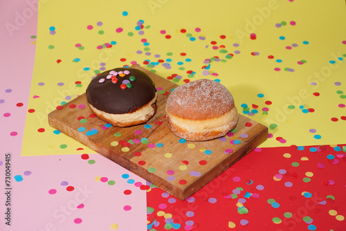 Traditional German Carnival Sweets  Berliner, Pfannkuchen or Krapfen in front of a colourful background