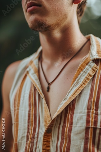 A man wearing a striped shirt and a necklace. Perfect for fashion blogs and lifestyle articles