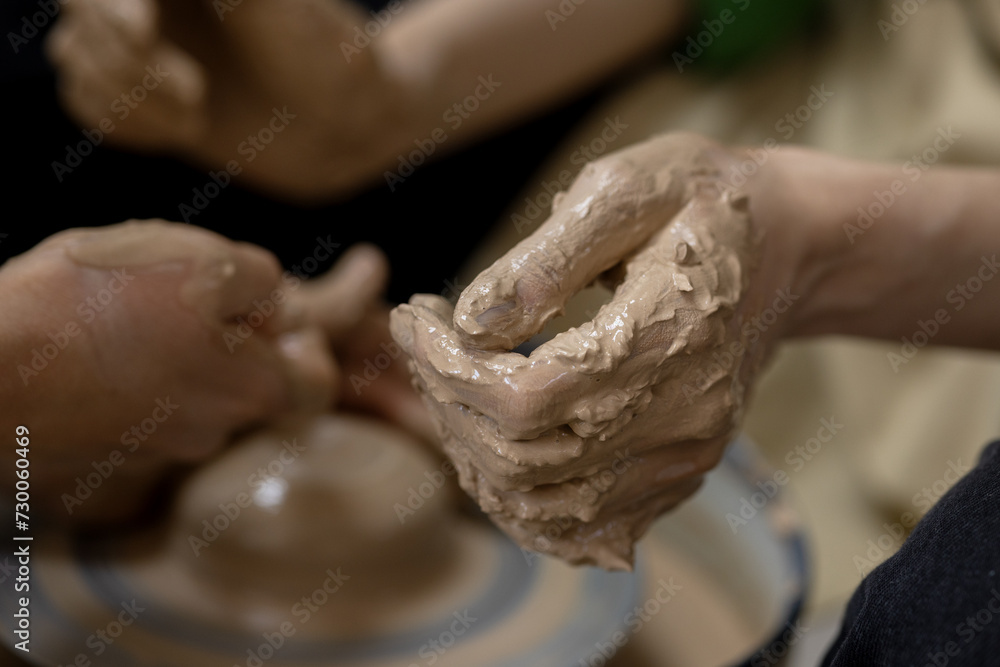 A woman's hand in clay after starting work on a potter's wheel. Close-up