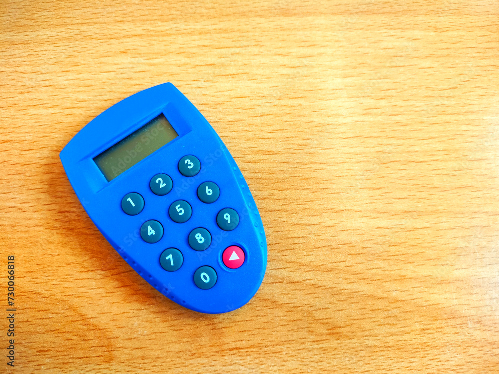 Blue token bank for internet banking isolated on wooden background Blue token bank for internet banking isolated on wooden background