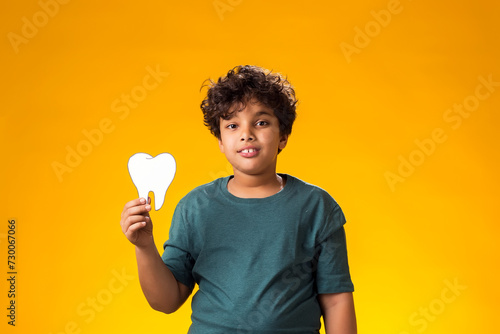 Child boy holding papercraft tooth. Dental health concept