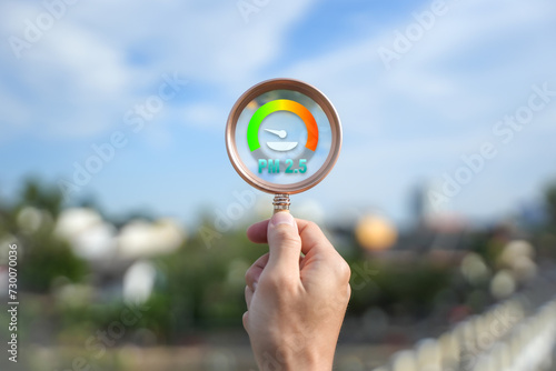 hand holding magnifying glass With the concept of a weather meter Ensure good air quality and clean outdoor air quality. Safe from pollution, PM 2.5 dust, has a green background.