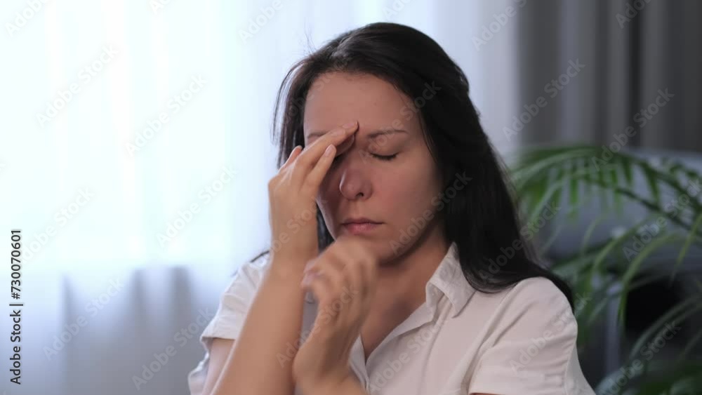 Lady in a white shirt expressing discomfort, possibly from tension or mental fatigue. Suitable for use in medical or therapeutic service promotions. Lady in a white shirt expressing discomfort, possibly from tension or mental fatigue. Suitable for use in medical or therapeutic service promotions.