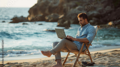 man sitting on a beach chair using a laptop by the sea © MP Studio