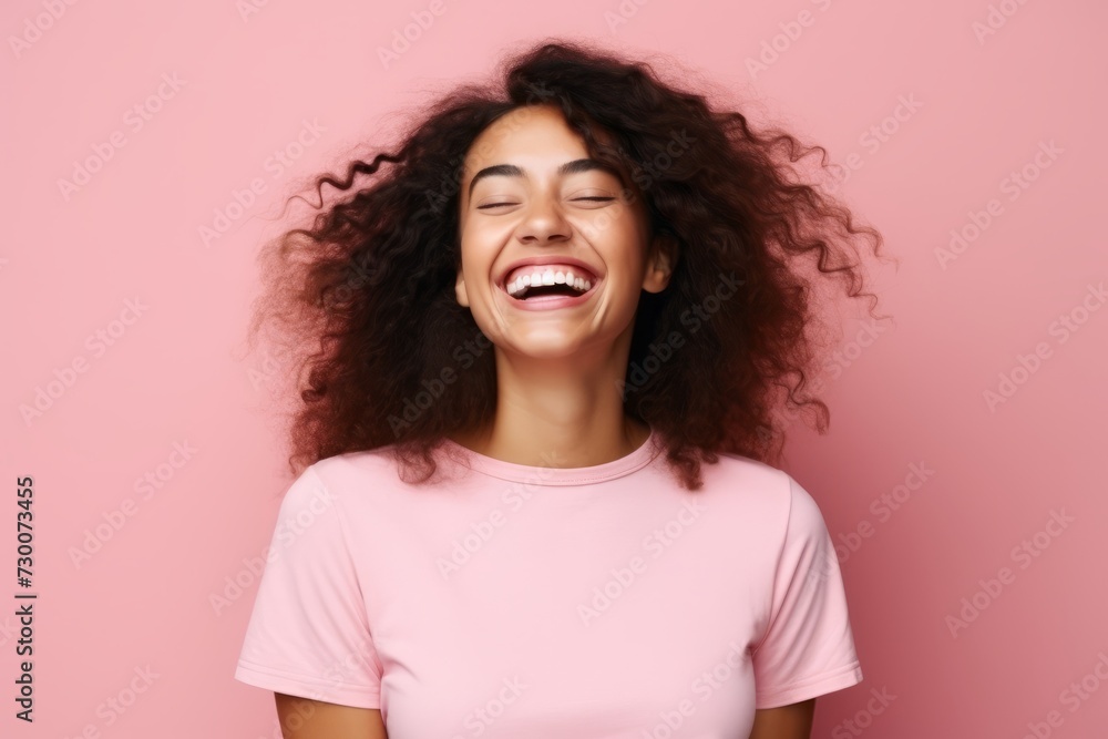 Portrait of a happy young african american woman laughing over pink background Portrait of a happy young african american woman laughing over pink background