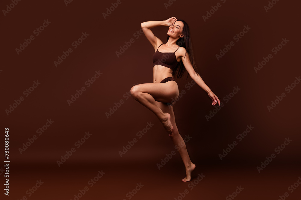 Unfiltered full length photo of stunning girl dressed underwear run to empty space hand on head isolated on dark brown color background