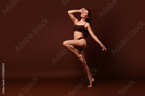 Unfiltered full length photo of stunning girl dressed underwear run to empty space hand on head isolated on dark brown color background