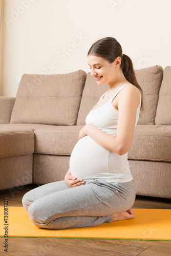 Pregnant woman meditating while sitting in yoga position. Meditating on maternity Pregnancy Yoga and Fitness concept at coronavirus time