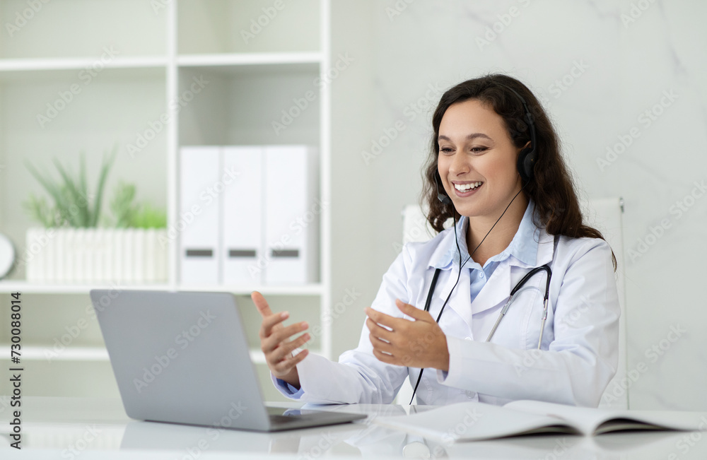 Cheerful young brunette lady in white coat has video call Cheerful young brunette lady in white coat has video call