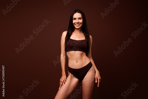 No retouch photo of adorable lovely confident woman feeling comfortable in fashion lingerie isolated on brown color background © deagreez