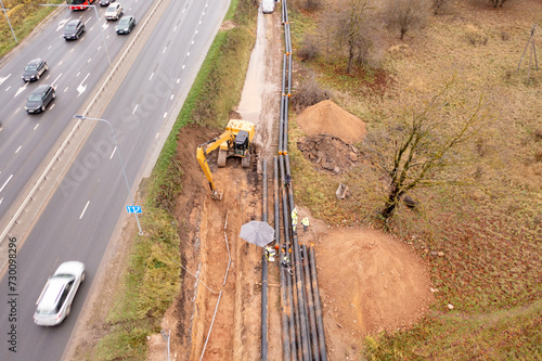 Obraz na plátně Drone photography of sewage pipe being lade down i a ditch by a road during autu