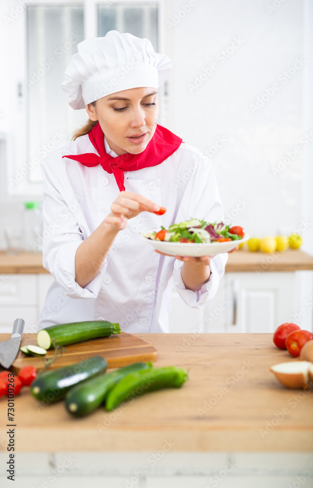 Portrait of woman chef decorating salad Portrait of woman chef decorating salad