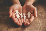 Symbolizing Solidarity: A Hand Grasps the Family Cutout Shape, Embodying Unity and Shared Purpose