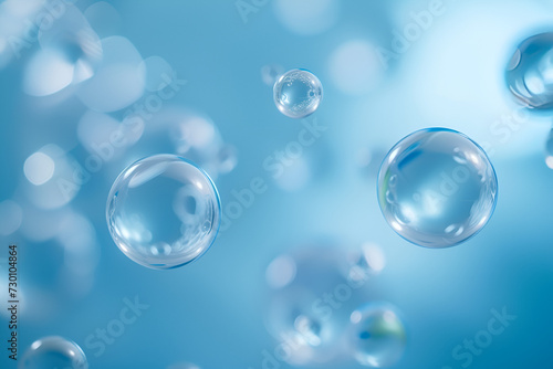 An artistic representation featuring a collection of transparent and glossy bubbles or droplets. They are floating against a soft blue background, creating a serene and ethereal atmosphere.