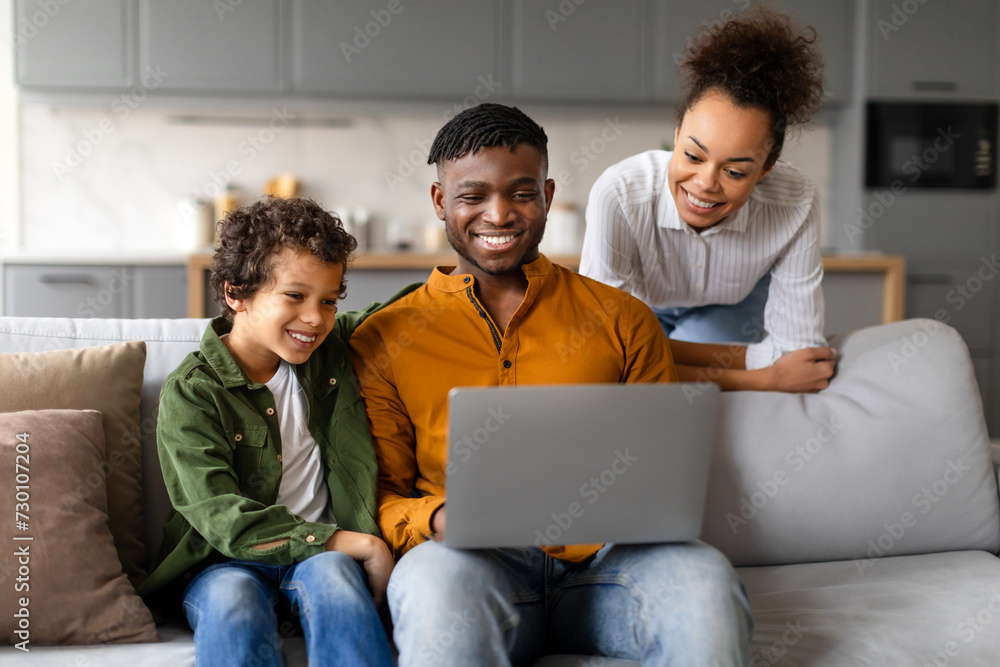 Happy family enjoying time together with laptop at home Happy family enjoying time together with laptop at home