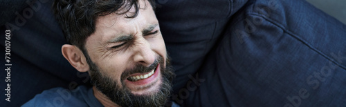 anxious man with beard in casual clothes suffering during breakdown, mental health awareness, banner