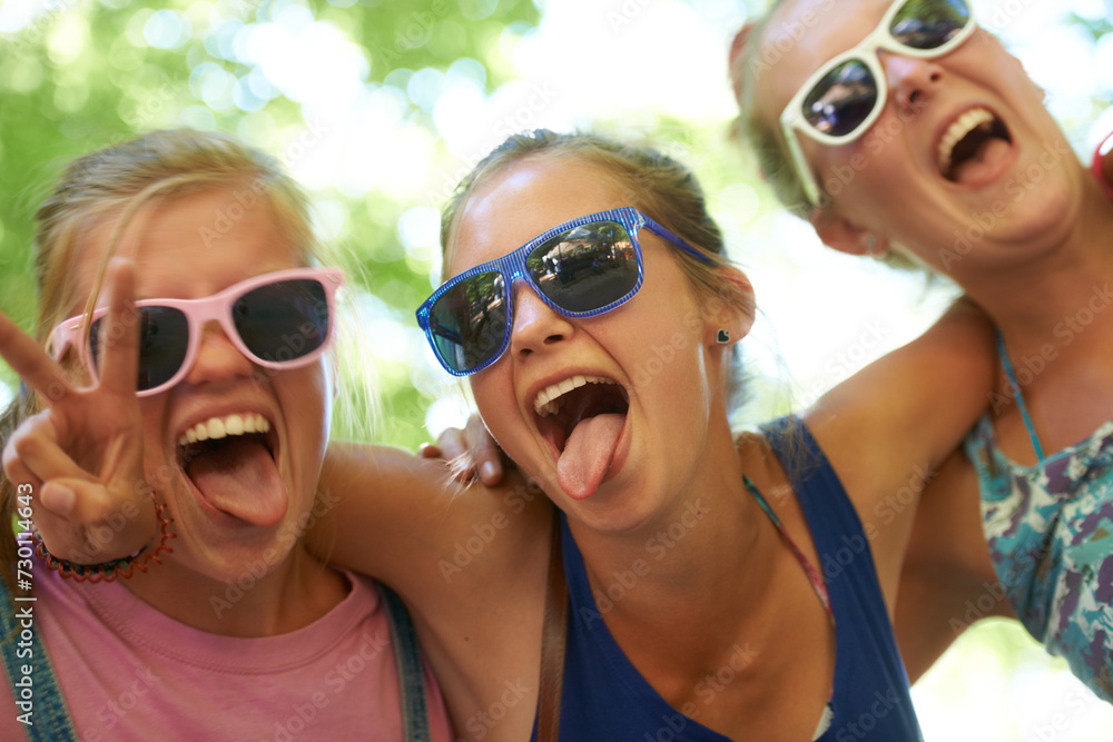 Portrait, music festival and women with sunglasses, funny and silly with happiness and bonding together. Funky eyewear, goofy or outdoor with friends or peace sign with embrace, excited or summer fun