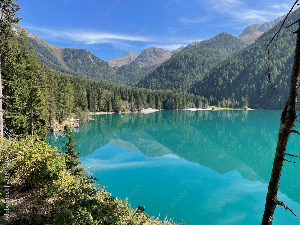 beautiful turquoise colored water of Lake Antholz surrounded with coniferous forests and high mountains