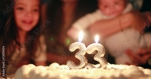 Wall Mural Blowing birthday candle with the number 33 closeup celebration