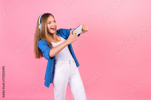 Photo of impressed excited girl wear blue shirt listening music headphones tacking photo empty space isolated pink color background