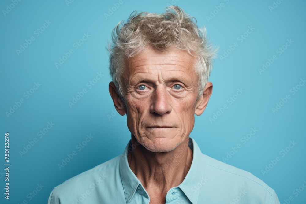 Portrait of a senior man looking at camera on a blue background