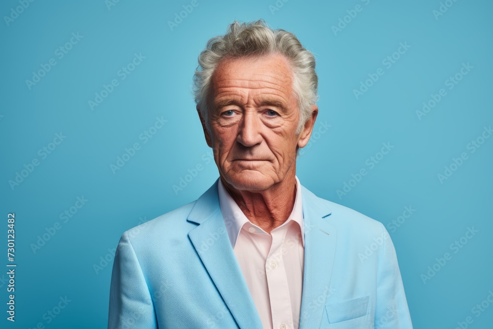 Portrait of senior man with grey hair and blue suit isolated on blue background. Portrait of senior man with grey hair and blue suit isolated on blue background.