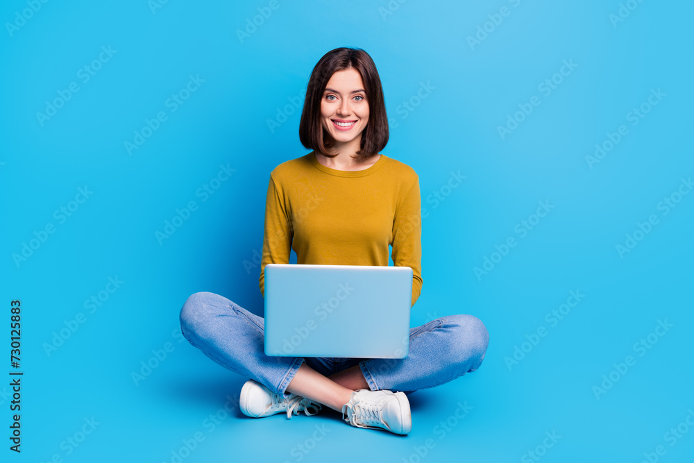 Full length photo of funky sweet lady dressed shirt working modern gadget empty space isolated blue color background Full length photo of funky sweet lady dressed shirt working modern gadget empty space isolated blue color background