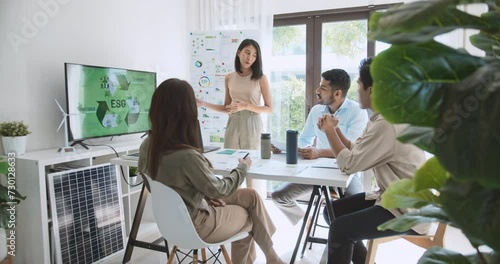 Asian woman lead young group of multiethnic businesspeople in team meeting, using laptop computer for ESG topic presentation on monitor. Sustainable business practice, people work at home concept photo