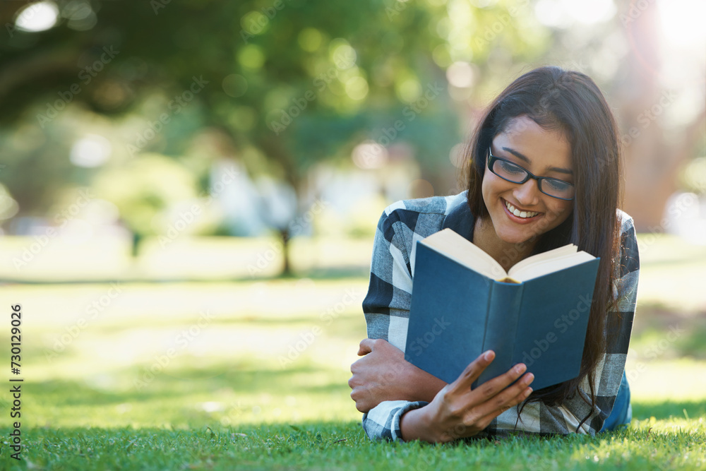 Happy woman, student and reading book in nature for literature, studying or story on green grass. Female person, smart or young adult with smile or glasses for chapter, learning or outdoor education Happy woman, student and reading book in nature for literature, studying or story on green grass. Female person, smart or young adult with smile or glasses for chapter, learning or outdoor education