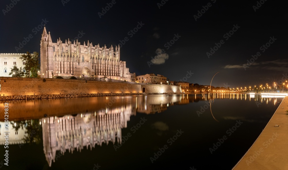 panorama nightime view of the Mallorca Cathedral in downtown Palma with reflections in the water panorama nightime view of the Mallorca Cathedral in downtown Palma with reflections in the water