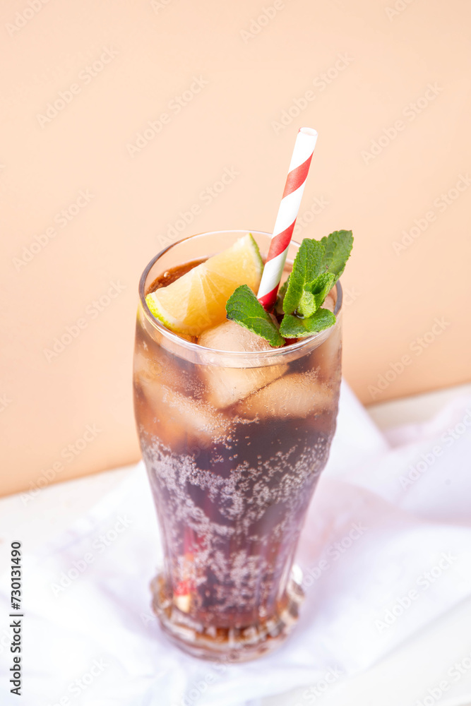 Cuba Libre or long island iced tea cocktail with strong drinks, cola, lime and ice in glass, cold long drink or lemonade Cuba Libre or long island iced tea cocktail with strong drinks, cola, lime and ice in glass, cold long drink or lemonade