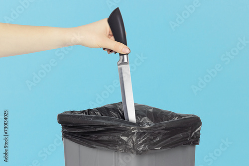 Canvas Print throw the knife in the trash, kitchen knife in hand in front of the trash can, g