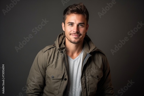 Portrait of a handsome young man in a jacket on a dark background © Iigo
