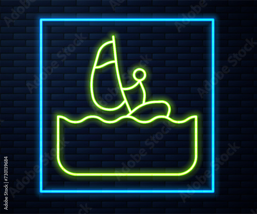 Glowing neon line Windsurfing icon isolated on brick wall background. Vector