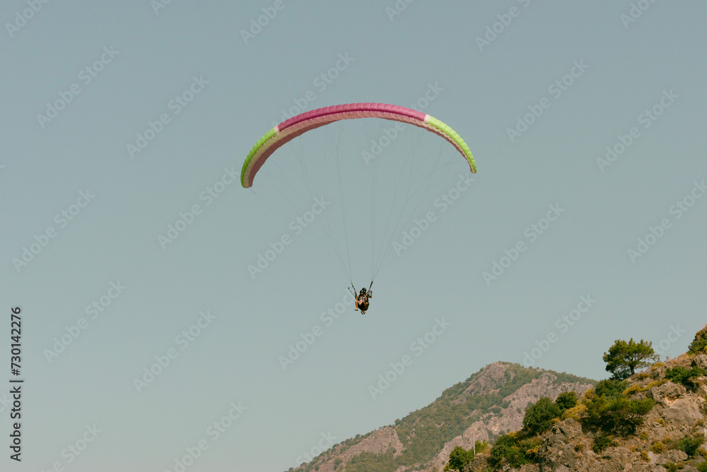 Pilot and passenger paragliding on sunny day Pilot and passenger paragliding on sunny day